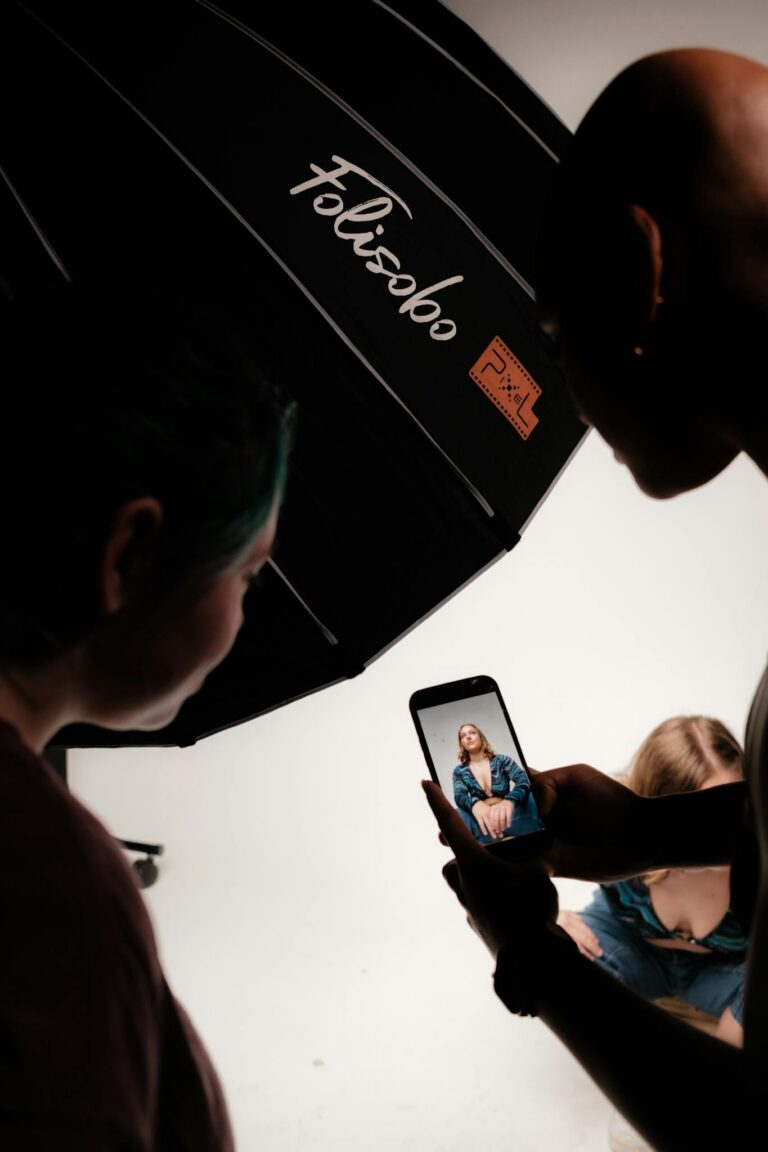 A behind-the-scenes look at a studio photoshoot capturing a model using a smartphone.