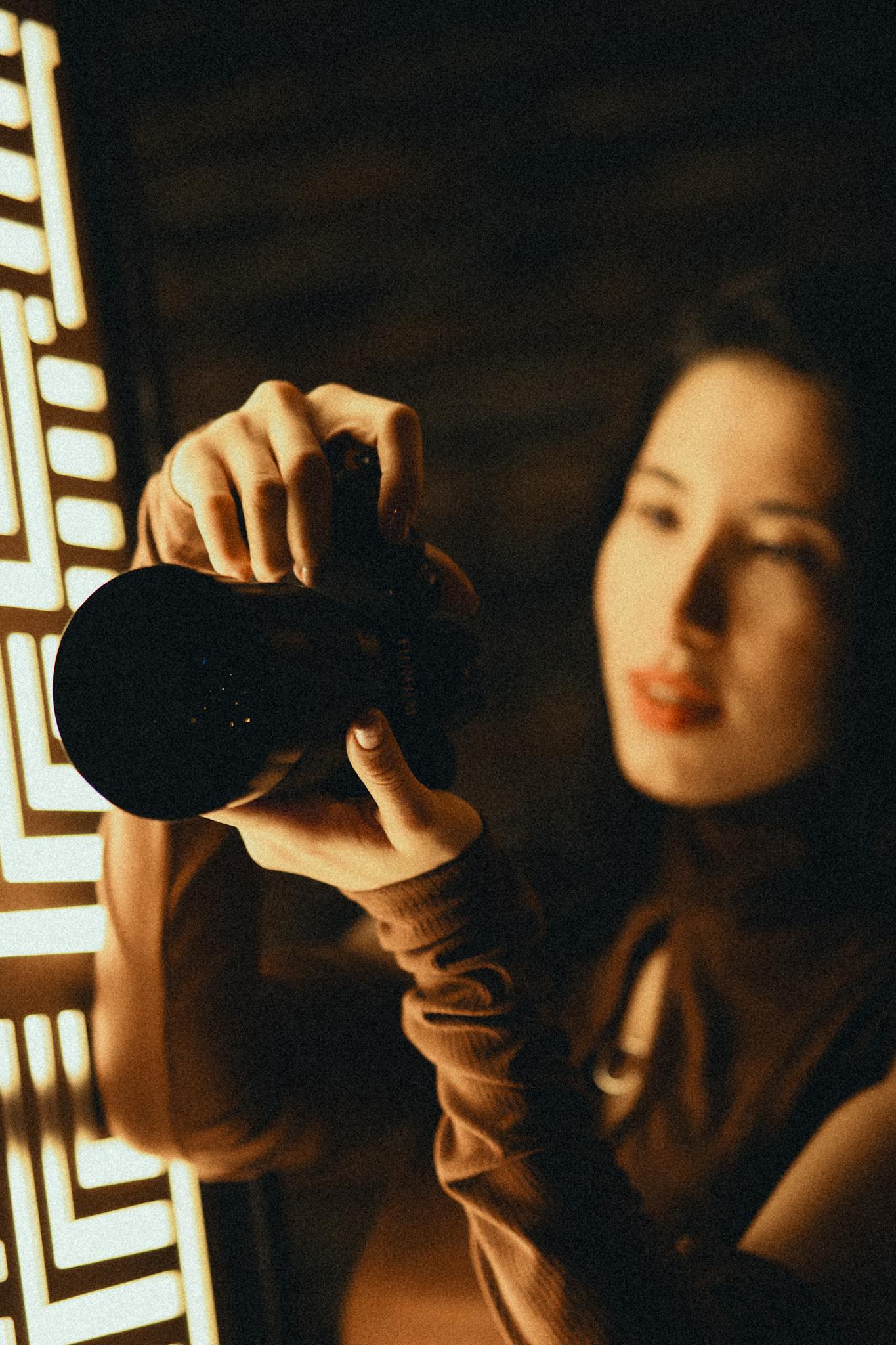 Stylish woman capturing a moment with DSLR camera in warm light.